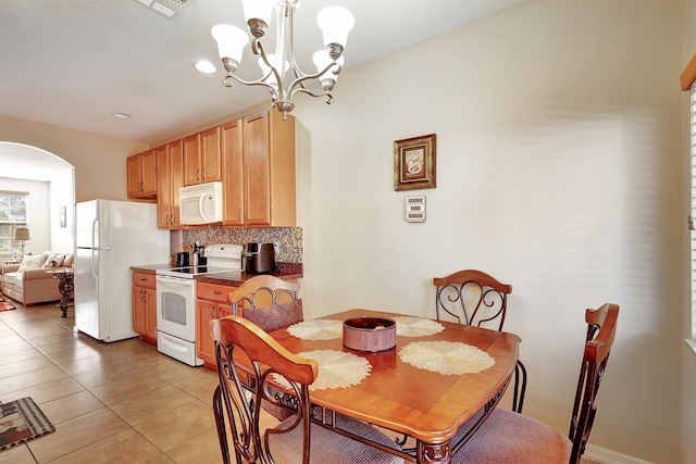 dining space with light tile patterned floors and a notable chandelier