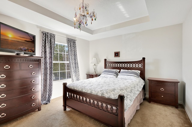 bedroom featuring a notable chandelier, light carpet, and a tray ceiling