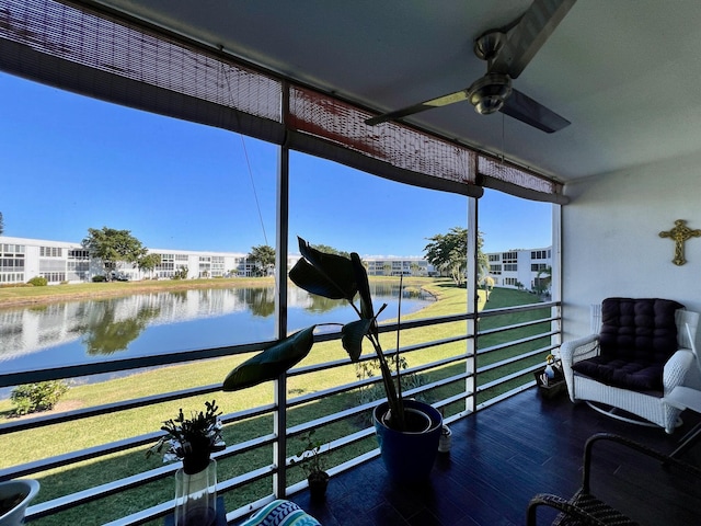 sunroom featuring a water view and ceiling fan