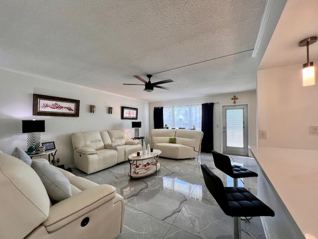 living room featuring ceiling fan and a textured ceiling