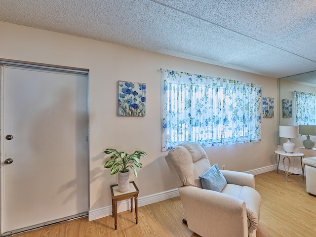 sitting room with a textured ceiling and light hardwood / wood-style flooring