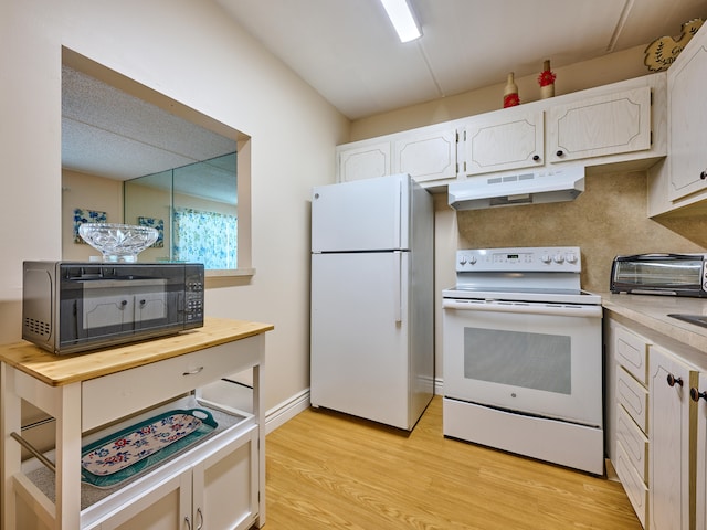 kitchen featuring white cabinets, pendant lighting, white appliances, and light wood-type flooring