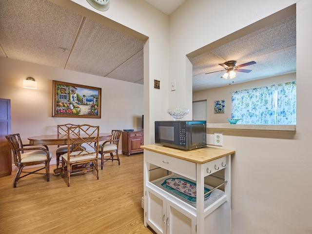 kitchen with wood counters, a textured ceiling, light hardwood / wood-style floors, and ceiling fan