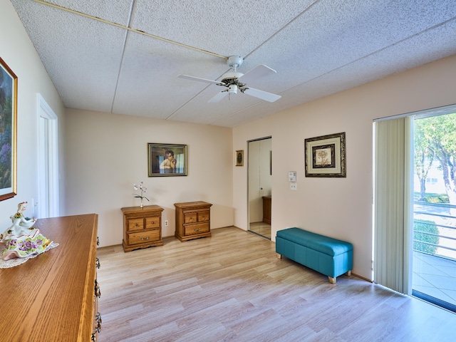 living area featuring ceiling fan, light hardwood / wood-style flooring, and a textured ceiling