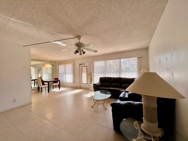 living room with ceiling fan, plenty of natural light, and a textured ceiling