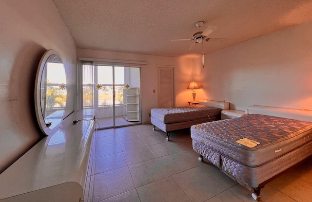 bedroom featuring light tile patterned floors, a textured ceiling, access to outside, and ceiling fan