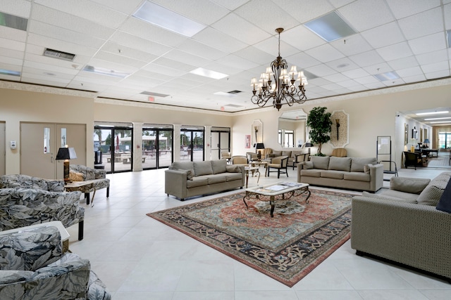 living room featuring a paneled ceiling, plenty of natural light, and a chandelier