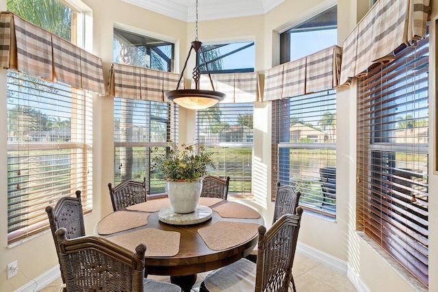 dining space with light tile patterned flooring, ornamental molding, and a wealth of natural light