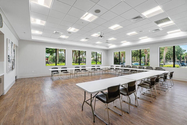 dining space with a drop ceiling and wood-type flooring