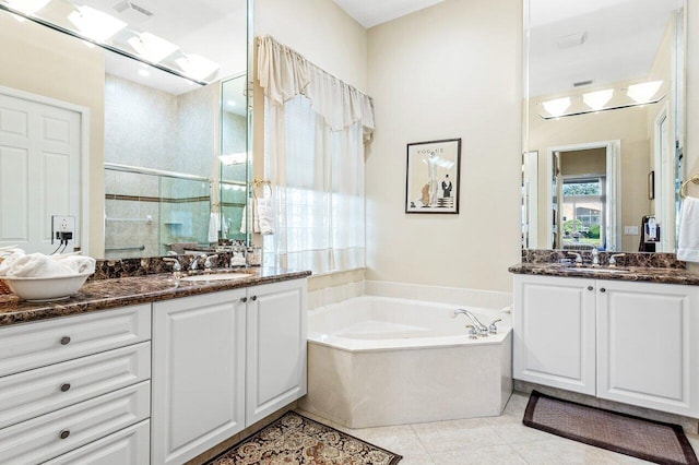 bathroom featuring plus walk in shower, vanity, and tile patterned floors