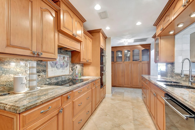 kitchen with decorative backsplash, light stone counters, sink, black appliances, and light tile patterned floors