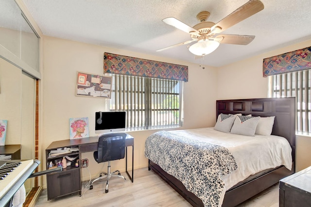 bedroom featuring ceiling fan, a closet, light hardwood / wood-style floors, and a textured ceiling