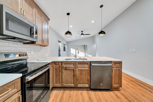 kitchen featuring ceiling fan, sink, light hardwood / wood-style floors, vaulted ceiling, and appliances with stainless steel finishes