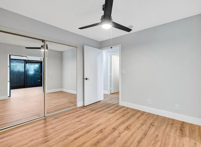 unfurnished bedroom featuring ceiling fan, a closet, and light hardwood / wood-style flooring