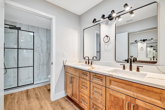 bathroom with hardwood / wood-style flooring, vanity, toilet, and an enclosed shower