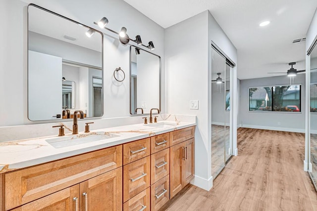 bathroom with hardwood / wood-style flooring, ceiling fan, and vanity