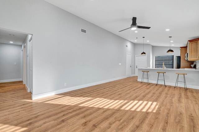 unfurnished living room featuring ceiling fan and light wood-type flooring