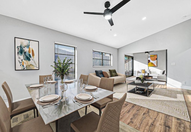 dining area featuring ceiling fan, wood-type flooring, and lofted ceiling