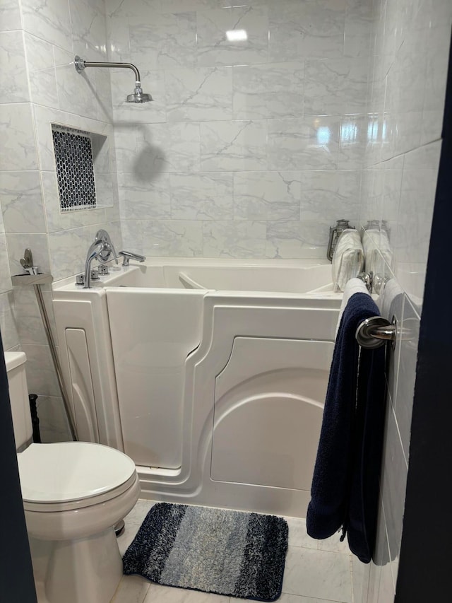 bathroom with a tub to relax in, tile walls, and toilet