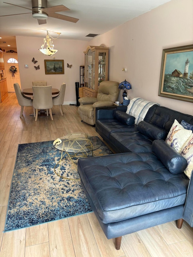 living room featuring hardwood / wood-style floors and ceiling fan with notable chandelier