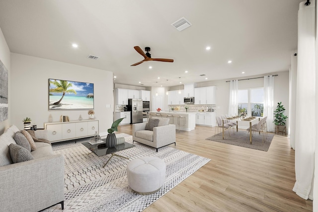 living room featuring ceiling fan and light wood-type flooring