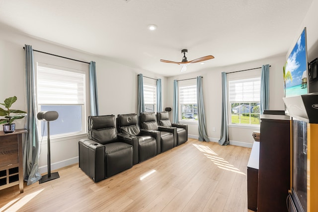 home theater featuring light wood-type flooring and ceiling fan