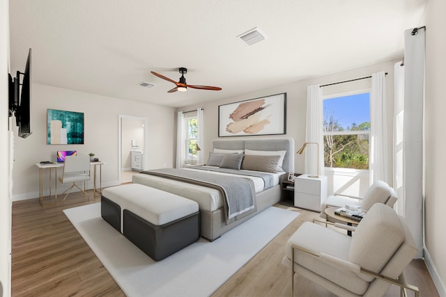 bedroom featuring ceiling fan, light hardwood / wood-style floors, and connected bathroom