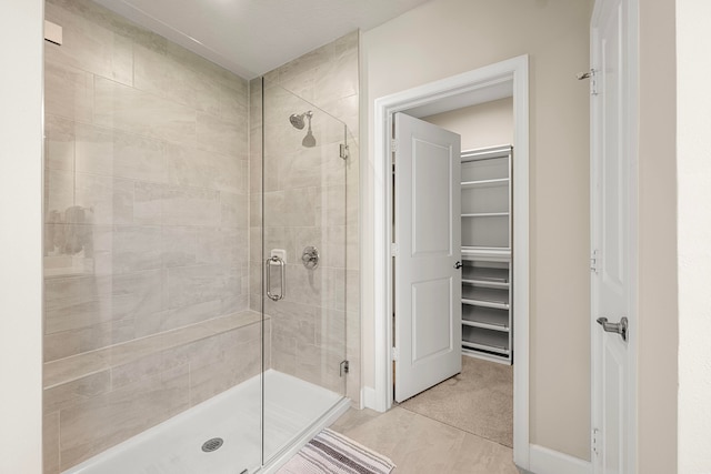 bathroom with tile patterned floors and a shower with door