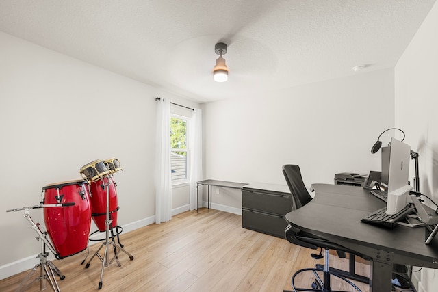 home office featuring light hardwood / wood-style flooring and a textured ceiling