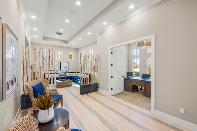 sitting room featuring a tray ceiling and light hardwood / wood-style flooring