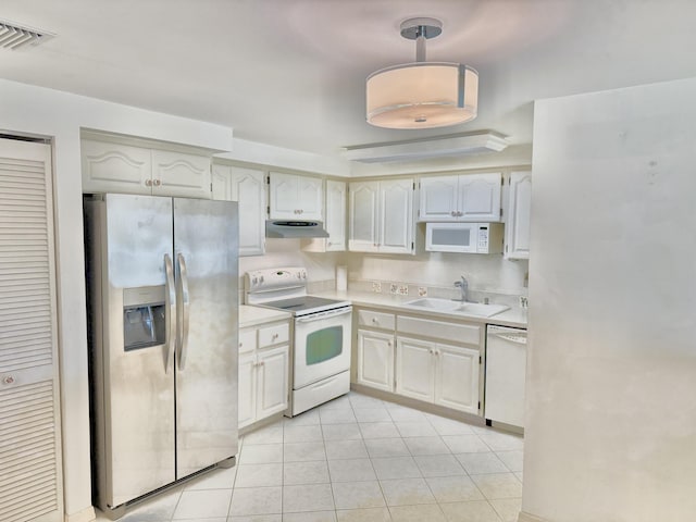 200 SE Four Winds Dr Unit 213, Stuart, FL 34996 - kitchen featuring white appliances, under cabinet range hood, light tile patterned flooring, and light countertops