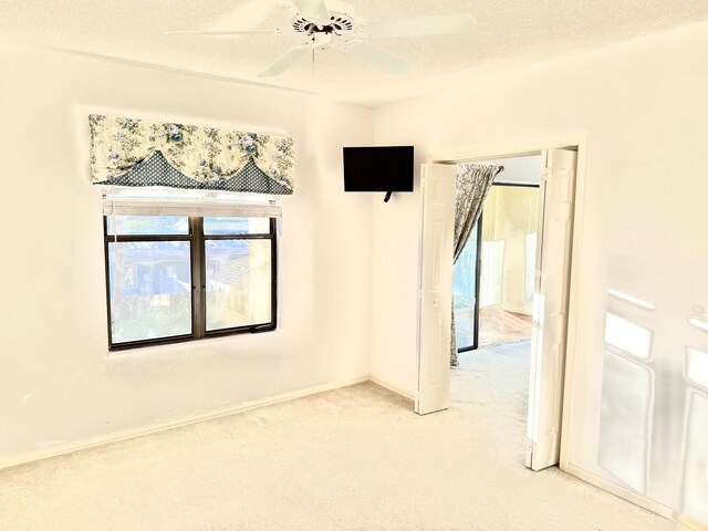 200 SE Four Winds Dr Unit 213, Stuart, FL 34996 - empty room with light colored carpet, a textured ceiling, and ceiling fan