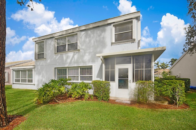 back of property featuring a sunroom and a yard