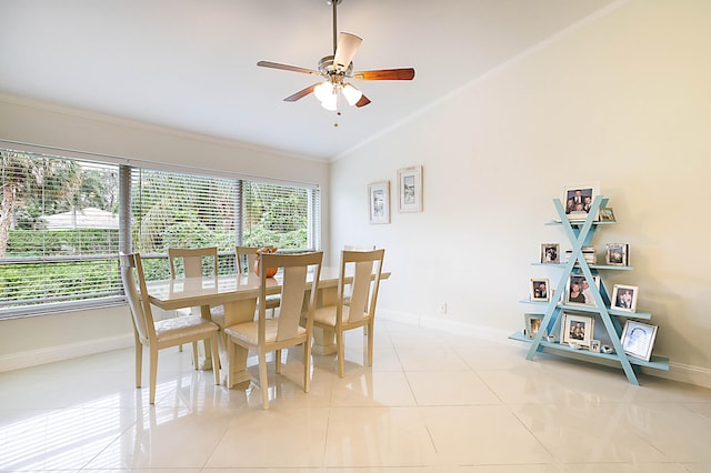 dining space with crown molding, light tile patterned flooring, lofted ceiling, and ceiling fan