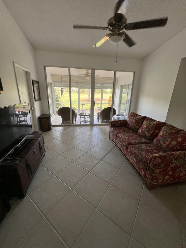 tiled living room featuring ceiling fan and a textured ceiling