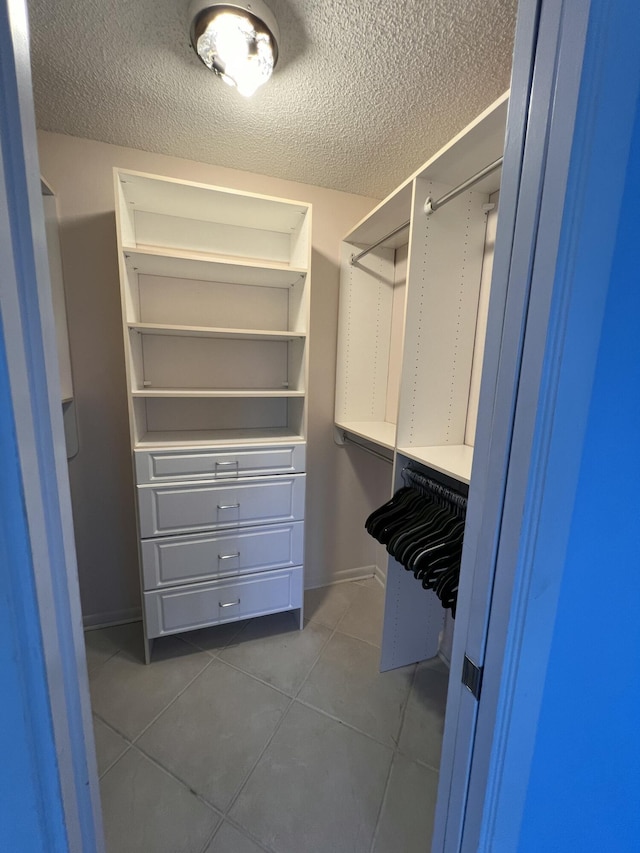 walk in closet featuring dark tile patterned flooring