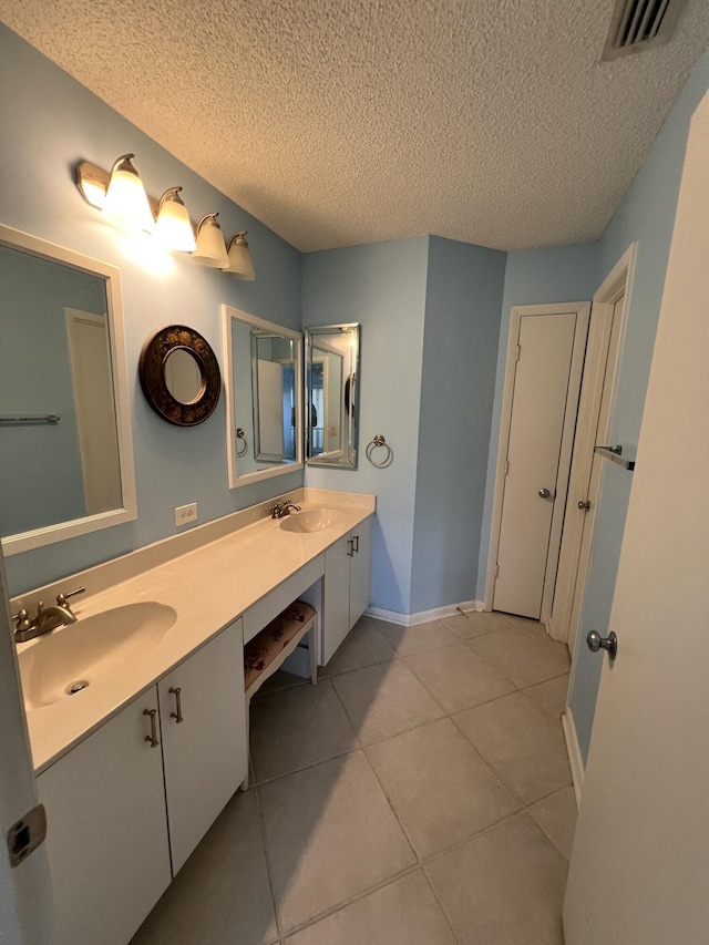 bathroom featuring tile patterned floors, visible vents, a sink, and double vanity