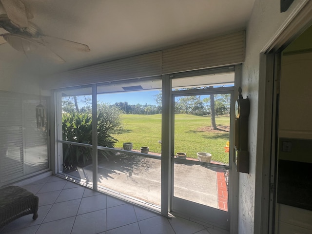 doorway with a wealth of natural light, light tile patterned flooring, and ceiling fan