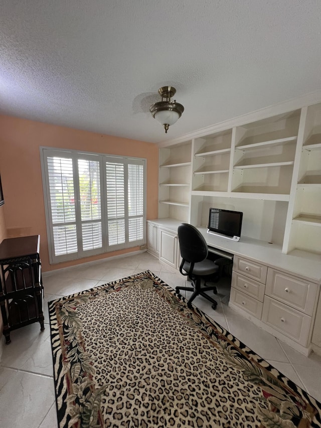 office with a textured ceiling, built in desk, and built in features