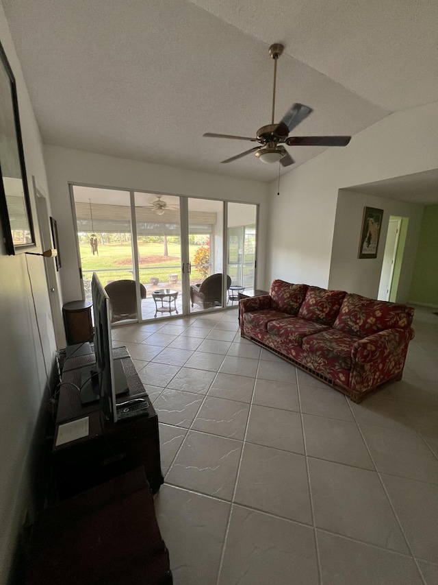 living area with light tile patterned floors, a ceiling fan, a sunroom, vaulted ceiling, and a textured ceiling