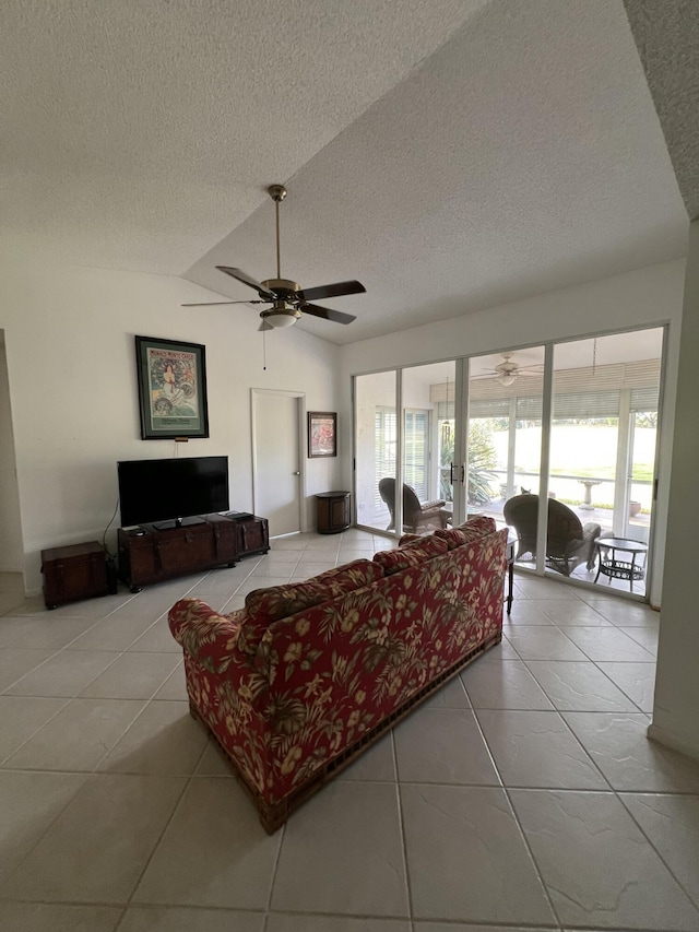 living room featuring a textured ceiling, ceiling fan, light tile patterned floors, and vaulted ceiling