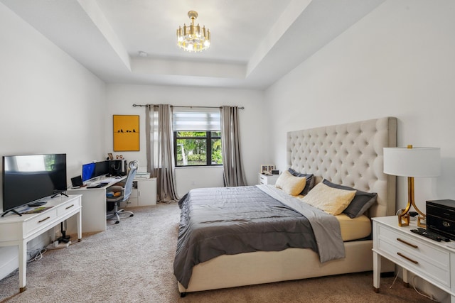 carpeted bedroom featuring a tray ceiling and a chandelier