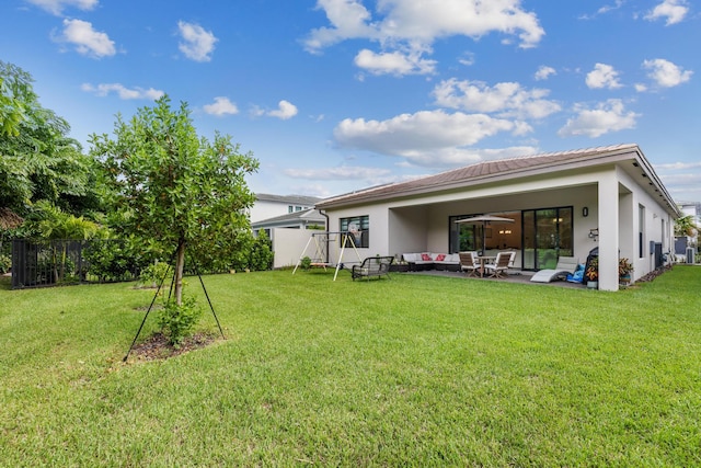 back of house with outdoor lounge area, ceiling fan, a patio area, and a lawn