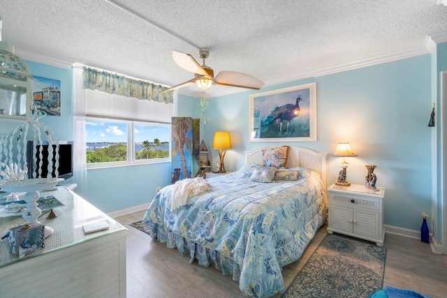 bedroom featuring hardwood / wood-style floors, a textured ceiling, ceiling fan, and ornamental molding