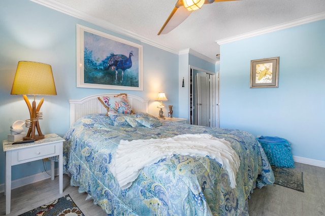 bedroom featuring hardwood / wood-style floors, a closet, ceiling fan, and crown molding