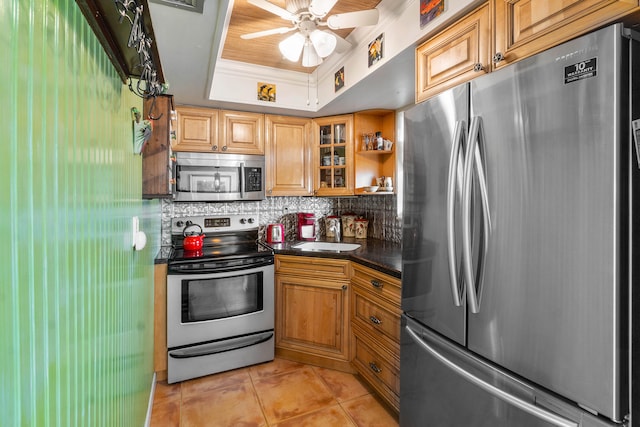 kitchen featuring appliances with stainless steel finishes, tasteful backsplash, a tray ceiling, ceiling fan, and light tile patterned floors