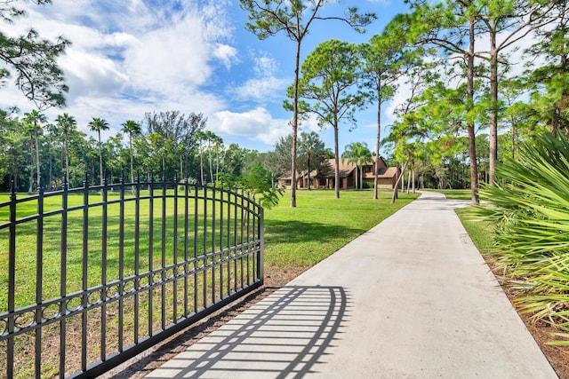 view of gate with a lawn