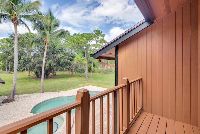 wooden deck featuring a lawn