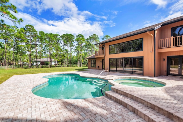 view of swimming pool featuring an in ground hot tub, a yard, and a patio