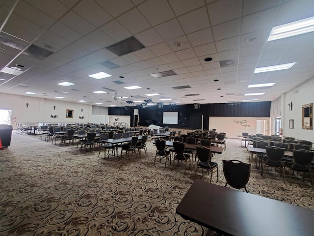 carpeted dining area with a drop ceiling